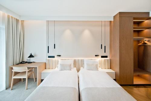 two beds in a room with a desk at Hotel Molo Resort in Osiek