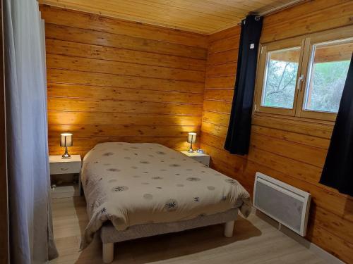 にあるChalet ICAREの木製の壁の部屋にあるベッドのある寝室
