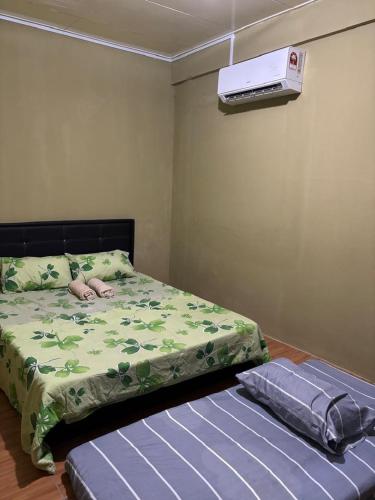 a bedroom with a bed and a air conditioner on the wall at Kuzha Homestay in Kota Kinabalu