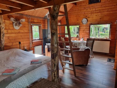 a bedroom with a bed in a log cabin at B&B de Prieelhoeve in Almere