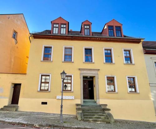 a yellow building with a door and a street light at Bike & Relax in Bernburg