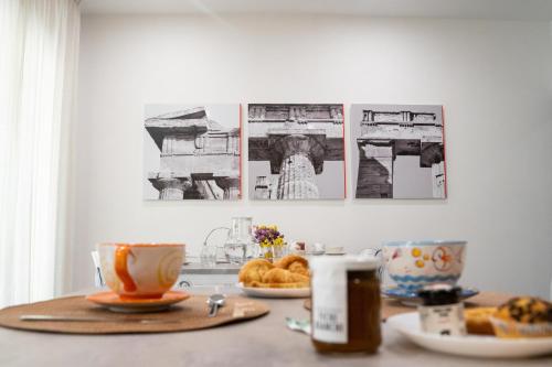 a table with tea cups and pastries on it at hiPaestum B&B in Paestum