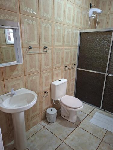 a bathroom with a toilet and a sink and a shower at Casa Ribeiro in Canguçu