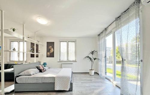 ein Schlafzimmer mit einem Bett und einem großen Fenster in der Unterkunft Villa 2 in Cassano dʼAdda
