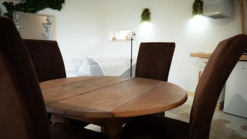 a wooden table and chairs in a room at Le Refuge Des Saisons 