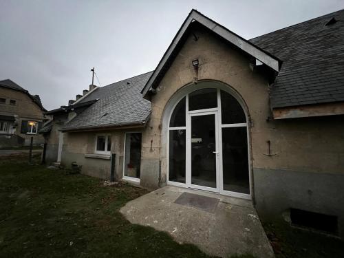 a house with a large glass door in a yard at Le Refuge Des Saisons 