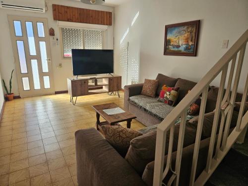 a living room with a couch and a flat screen tv at Alquiler temporario en zona centrica de San Nicolas De Los Arroyos in San Nicolás de los Arroyos