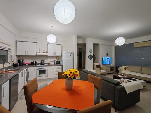 a kitchen and living room with a table with flowers on it at Kyrenia Turtle Village Sea Villa with Garden in Kérynia