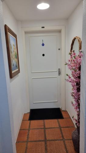 a hallway with a white door with a black door mat at Mariechen 603, Perfeito, Central in Torres