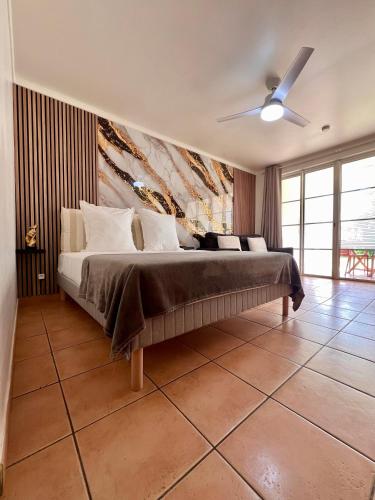 a bedroom with a bed and a ceiling fan at cœur d hibiscus in Sainte-Luce