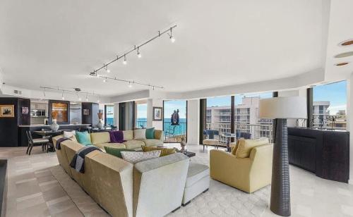 a living room with couches and chairs and a table at Oceanfront Three-Bedroom Condo with Panoramic View in South Palm Beach