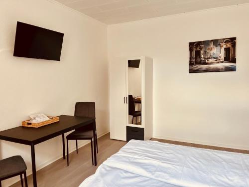 a bedroom with a bed and a table and a desk at Apartment-am-Burgberg, Harztor in Harztor