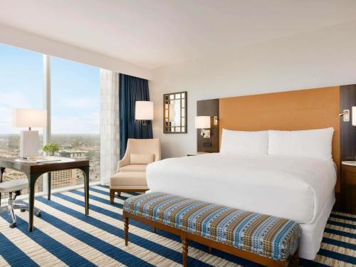 a hotel room with a large bed and a desk at Fairmont Austin in Austin