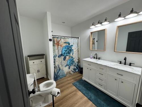 a bathroom with a sink and a toilet and a mirror at Hidden gem at the lake 4 bedrooms in Moneta