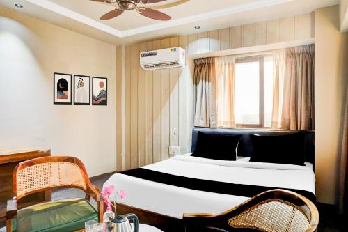 1 dormitorio con 1 cama, ventana y sillas en Collection O Viman Nagar Downtown Formerly Hotel Cilantro, en Pune