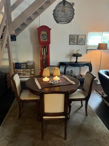 a dining room with a table and a grandfather clock at Vakantiewoning Fruitschuur de Morel in Venlo