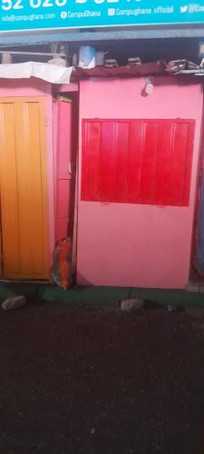 a group of doors with different colors on them at Unit with bed in Busy Osu in Accra