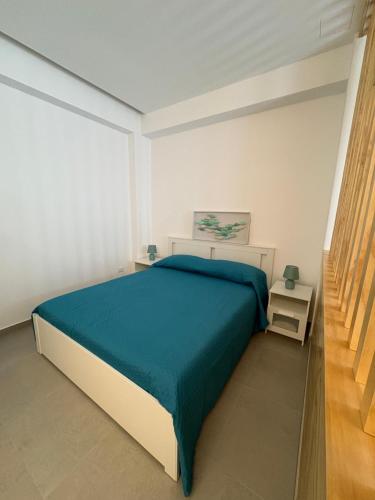 a bedroom with a large bed with a blue blanket at La Nassa e il Faro in Porticello