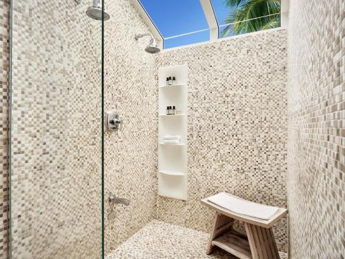 una ducha con un banco al lado de una puerta de cristal en Fairmont El San Juan Hotel, en San Juan