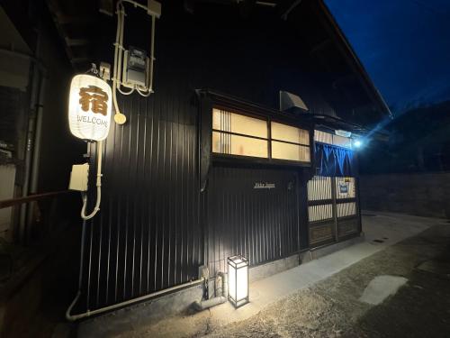 een gebouw met een bord aan de zijkant 's nachts bij Jikka Japan in Izumi-Sano