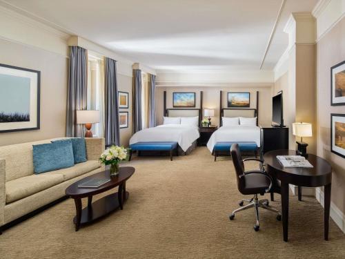 une chambre d'hôtel avec deux lits et un canapé dans l'établissement Fairmont Palliser, à Calgary