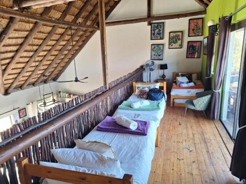 a bedroom with two beds in a room with wooden floors at Twenty Four Mabalingwe Nature Reserve in Warmbaths