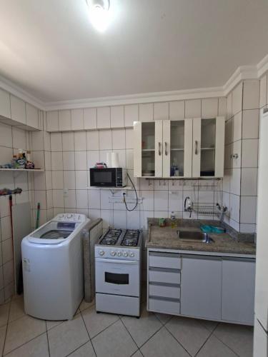a kitchen with a white stove and a sink at Ap Orla de Aracaju in Aracaju