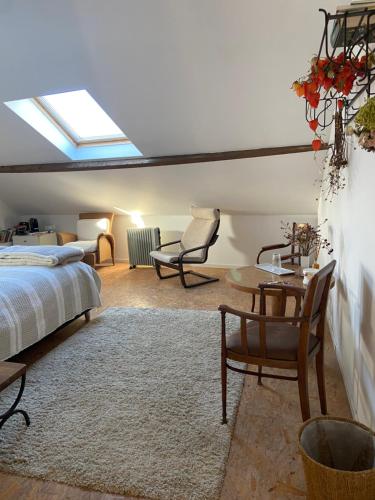 Pont-à-CellesにあるLe pigeonnier des voyageurs Le pigeonnier des voyageurs aéroport Charleroiのベッドとテーブルと椅子のある寝室