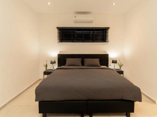 パラマリボにあるMon Plaisir Residenceの大きなベッドと2つのナイトスタンドを備えた寝室