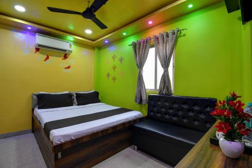 加尔各答Hotel O Star View的一间卧室设有绿色的墙壁、一张床和一张沙发