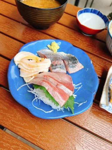 a blue plate of food on a wooden table at ペットok 古民家ふるさと真鶴 in Manazuru