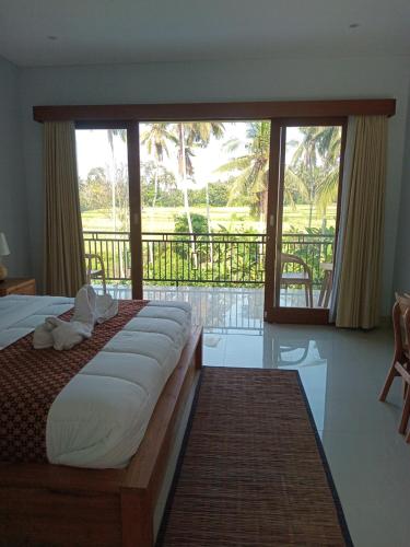 une chambre avec un lit avec vue sur une piscine dans l'établissement Jagadhita villa, à Ubud