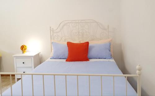 AlmeseにあるFiori e Frutti Guest Homeの白いヘッドボードと赤い枕が付いた白いベッド