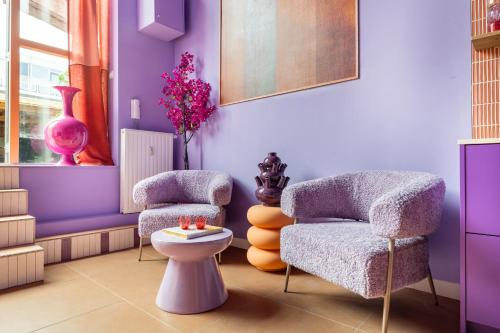 une pièce violette avec deux chaises et des toilettes dans l'établissement Lush Lofts, à Breda