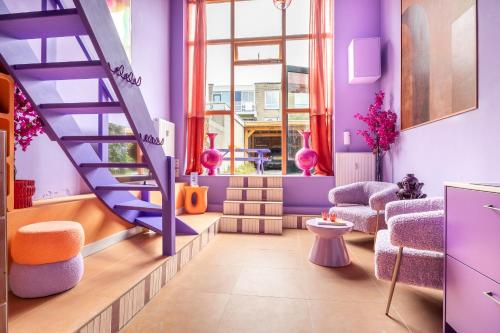 un salon avec des murs violets et un escalier en colimaçon dans l'établissement Lush Lofts, à Breda