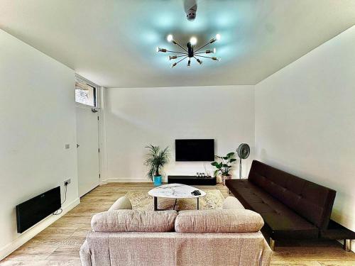 ein Wohnzimmer mit Sofa und Tisch in der Unterkunft Luxury Apartment with Grand Living Space London in London