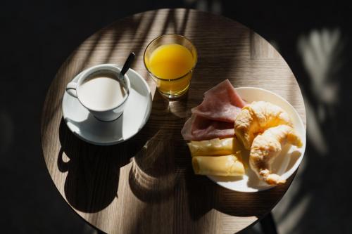 un tavolo con un piatto di cibo e un bicchiere di succo d'arancia di Ibis Puerto General San Martin a San Lorenzo