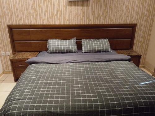a bed with two pillows on top of it at النخيل للشقق الفندقية in Jeddah