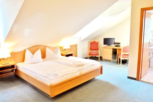 a bedroom with a bed and a desk with chairs at Hotel Alttolkewitzer Hof in Dresden