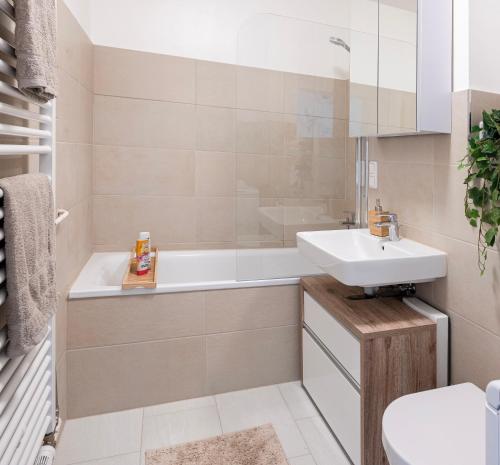a bathroom with a sink and a tub and a toilet at Moderne 2-Zimmer-Wohnung mit atemberaubender Skyline Aussicht auf Frankfurt! in Steinbach im Taunus