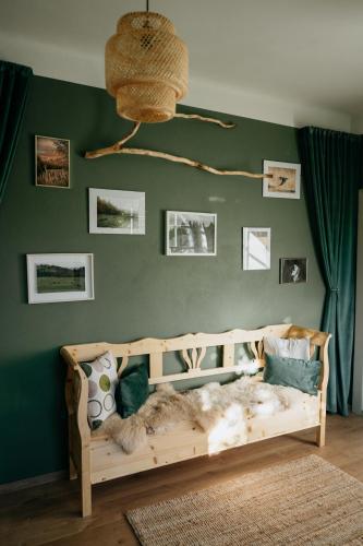 a bedroom with a wooden bed with a green wall at Stone House in Târgu Secuiesc