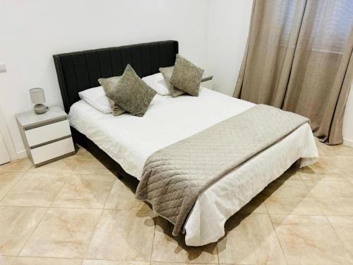 a bedroom with a bed with white sheets and pillows at Stylish 3-bedroom flat in Funchal in Funchal