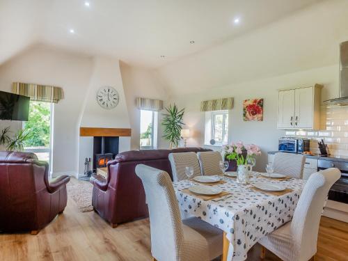 a kitchen and living room with a table and chairs at Bryn Awelon - Uk44122 in Moelfre