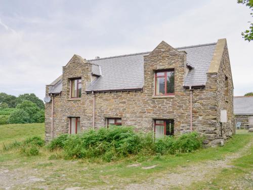 an old stone house in a field at Erw Goed Old Barn in Arthog