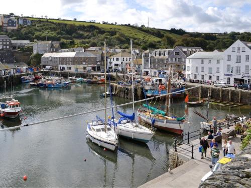 Un grupo de barcos están atracados en un puerto en Anneth Lowen, en Pentewan