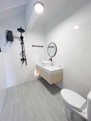 a bathroom with a sink and a mirror and a toilet at Saga Pool House 5BR, 200m from BEACH in North Pattaya