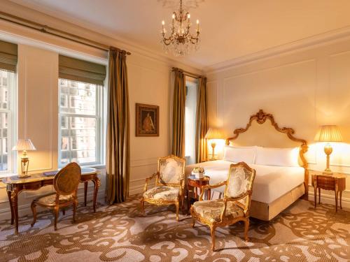 a bedroom with a bed and a table and chairs at The Plaza in New York