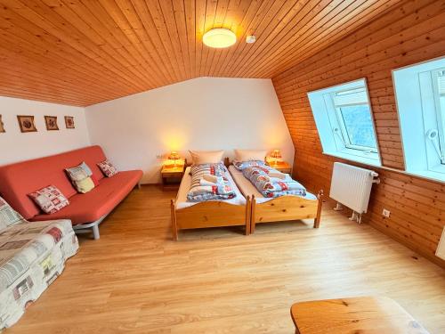 une chambre avec un lit et un canapé dans une pièce dans l'établissement Ferienhaus Frei 2 Titisee, à Titisee-Neustadt