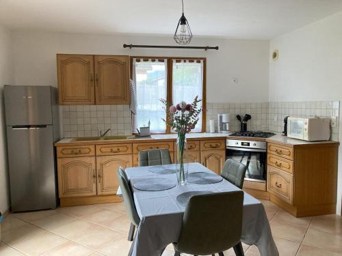 a kitchen with a table with a vase of flowers on it at Joli appartement cozy in Mercury