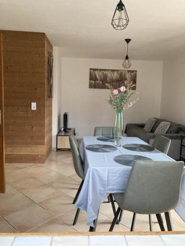 a dining room with a table with a vase of flowers at Joli appartement cozy in Mercury